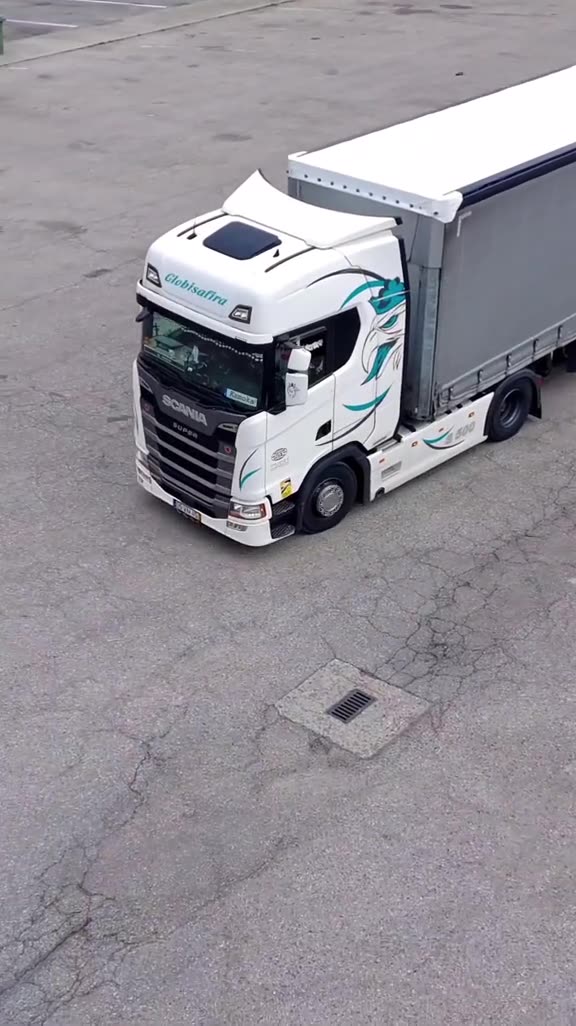 Truck with teal livery and grey curtain-side trailer seen from above